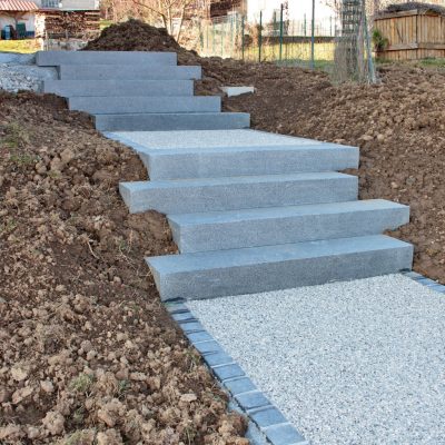 Escalier granit gris foncé avec palier en béton désactivé et ligne de pavés granit gris foncé chez un particulier à Chavanod, 74650