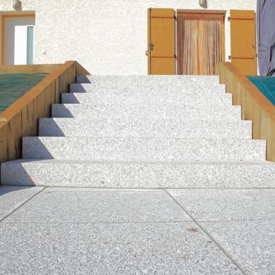Marches d’escalier en blocs granit gris clair et muret en poutres de chêne